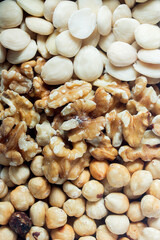 Close-up of an assortment of mixed dry fruit. The texture of walnuts, almonds, and hazelnuts as a background. Healthy and vegan food.
