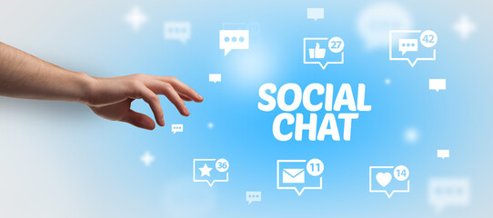 Close-Up of cropped hand pointing at SOCIAL CHAT inscription, social networking concept