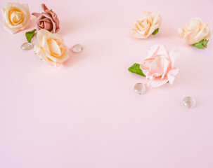 Roses background. Various pink roses flowers buds and petals scattered on pastel pink background, overhead view, copy space flat lay .Flowers composition. Frame made of rose flowers