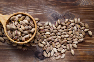 Pistachios in a Cup on a wooden background. Flat layout. Place for text.