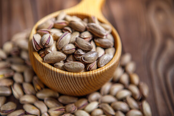 Pistachios in a Cup on a wooden background.  Place for text. Nuts close up