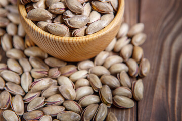 Pistachios in a Cup on a wooden background.  Place for text. Nuts close up