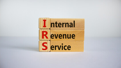 Concept word 'IRS - Internal Revenue Service' on wooden cubes and blocks on a beautiful white background. Business concept, copy space.