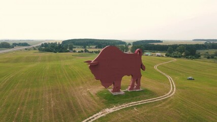 Huge bison statue in the middle of fields aerial view - Powered by Adobe