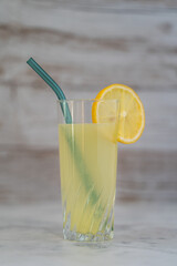 Lemonade with glass and reusable straw. Isolated with wood background.