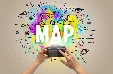 Close-up of a hand holding digital camera with abstract drawing and MAP inscription