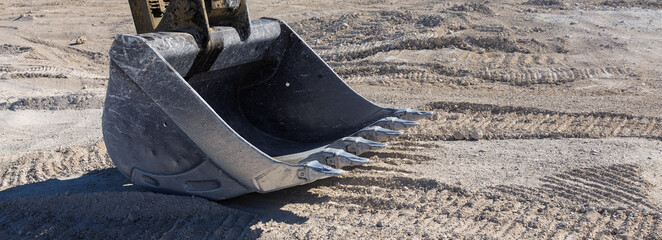A close-up of the bucket of a heavy large excavator in a quarry. © Mountains Hunter