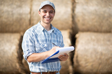 Smiling farmer writing on a document