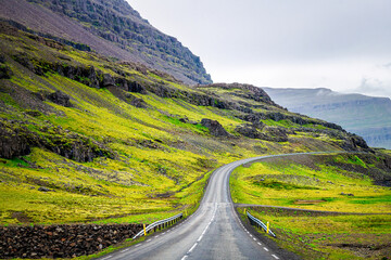 Ring road in east Iceland highway with green summer landscape mountains cliff on cloudy day and nobody empty near Djupivogur