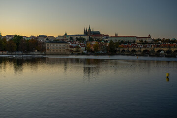Fototapeta na wymiar view of the Vltava river and Prague Castle St. Vitus Cathedral and Charles Bridge in the center of Prague at sunset. there are reflections on the river surface and the sky is illuminated by the sun