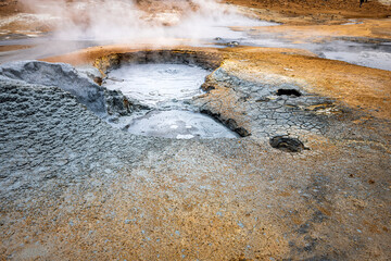 Hot steam bubbling boiling blue mud geyser in Hverir geothermal spot area in Iceland by Myvatn caldera lake closeup
