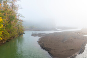 Foggy Fall Morning Fishing Along a Pacific Northwest River. Salmon are migrating up the Nooksack River with autumn colors showing on the maple and alder trees in this idyllic spot in nature.