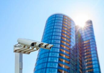 A modern CCTV camera performing surveillance and monitoring functions with a bokeh image of a...
