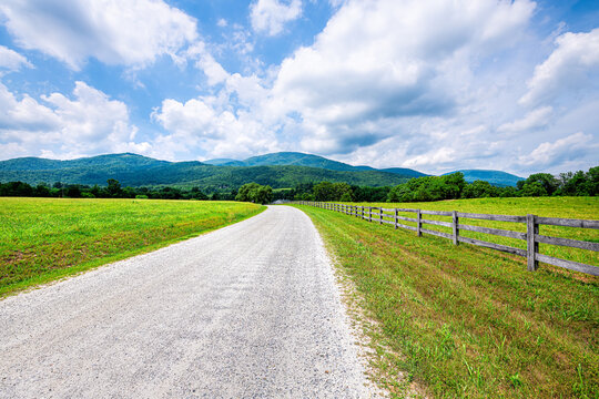 Farm road fence in Roseland, Virginia near Blue Ridge parkway mountains in summer with idyllic rural landscape countryside in Nelson County