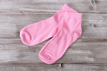 Obraz na płótnie Canvas Two, a pair of pink cotton classic socks on wooden background