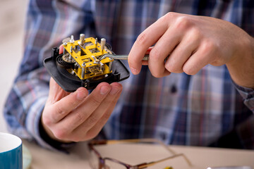 Young male watchmaker working in the workshop