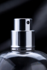 close up macro perfume spray bottle over dark luxury background. gloomy perfume container. copy space