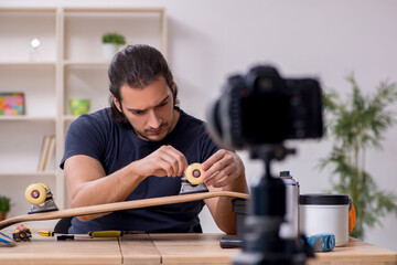 Young male skateboarder repairman recording video for his blog