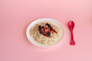 Oatmeal porridge with fresh frozen berries. Healthy breakfast.