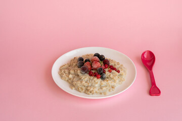 Oatmeal porridge with fresh frozen berries. Healthy breakfast.