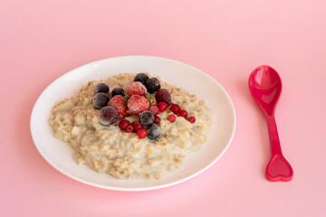 Oatmeal porridge with fresh frozen berries. Healthy breakfast.