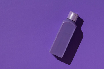 Monochrome image of a purple bottle on a purple background.