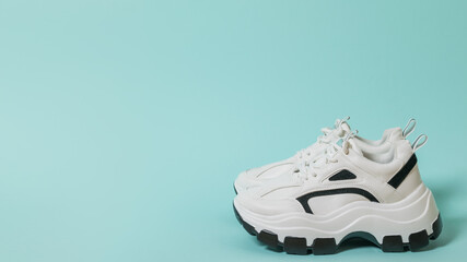 The ultra-modern sneakers on a high sole on a blue background. Place for text.