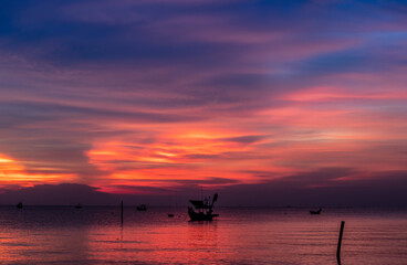 Fototapeta na wymiar Fishing boat with sunset on the beach in Thailand