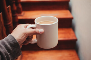 Cup of coffee in front of the stairs in the morning