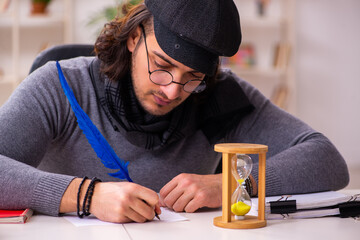 Young male writer in time management concept