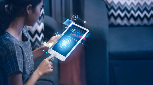 Asian businesswoman work from home using tablet technology modern futuristic using application interface software planning innovative information files data stats thinking ideas working late at night