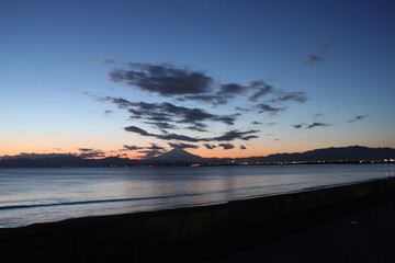 Fototapeta na wymiar 江ノ島海岸から見る夕日と伊豆半島のシルエット