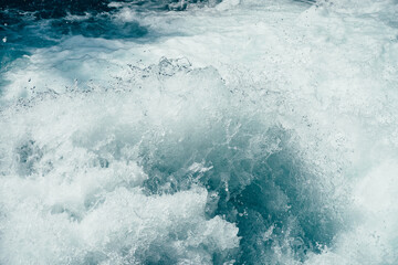 Frozen splashing in rapids of powerful mountain river. Surf of clear water  close-up. Nature...