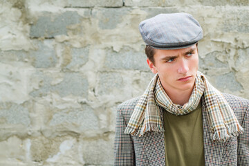 Retro and vintage old style. Stylish young man against a grey wall.