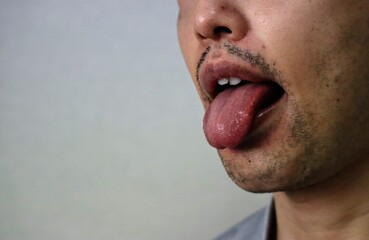 舌を出して相手を侮辱するポーズをする男性のクローズアップ
