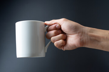 hand holding cup on black