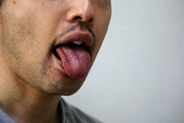舌を出して相手を侮辱するポーズをする男性のクローズアップ