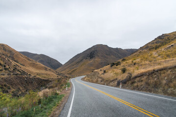 long road in yellow grass valley with sky and white cloud