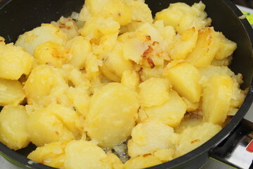 fresh fried potatoes with onions in a pan