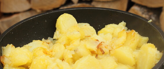 fresh fried potatoes with onions in a pan
