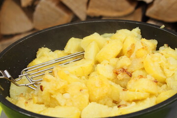fresh fried potatoes with onions in a pan