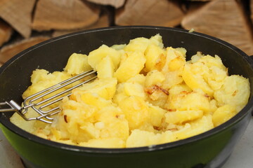 fresh fried potatoes with onions in a pan