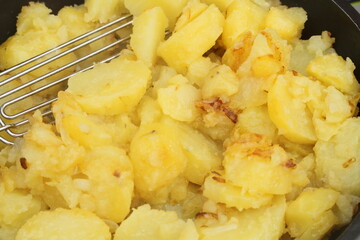 fresh fried potatoes with onions in a pan