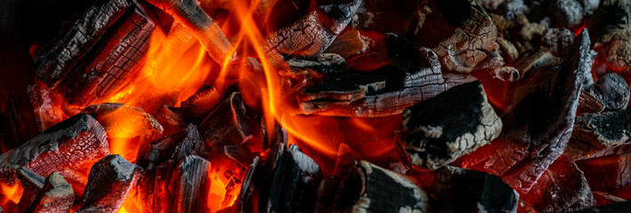 Barbecue. The fire is burning in the grill. Banner © Serhii