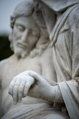 Mary holds Jesus's broken hand in a Victorian cemetery pieta, beautiful tenderness in natural light with copy space