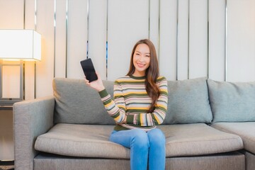 Portrait beautiful young asian woman use smart mobile phone on sofa