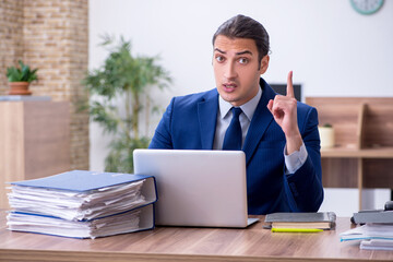 Young male employee unhappy with excessive work