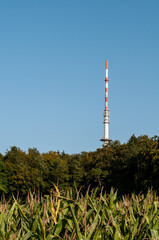 a concrete communication tower painted red and white