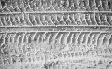 Protector tracks of car tires in the melted snow. Close-up.