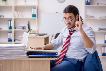 Young male employee unhappy with excessive work
